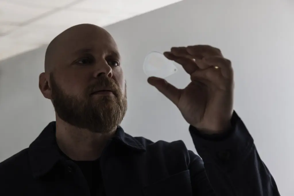 Dispelixin toimitusjohtaja Antti Sunnari tarkastelee silmälasiformaattiin kehitettyä Dispelixin valojohdenäyttökomponenttia.