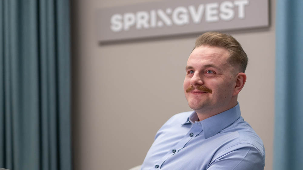 Springvestin asiantuntija hymyilee toimistolla