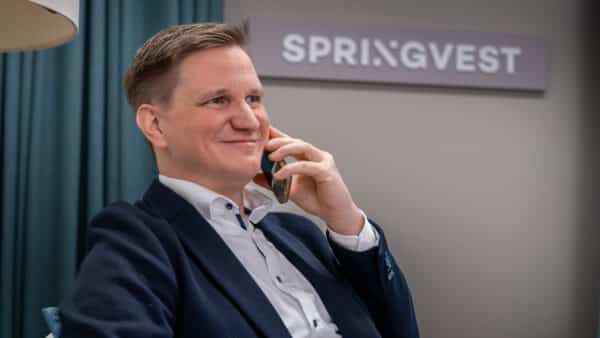Springvestin asiantuntija iloisena puhelimessa