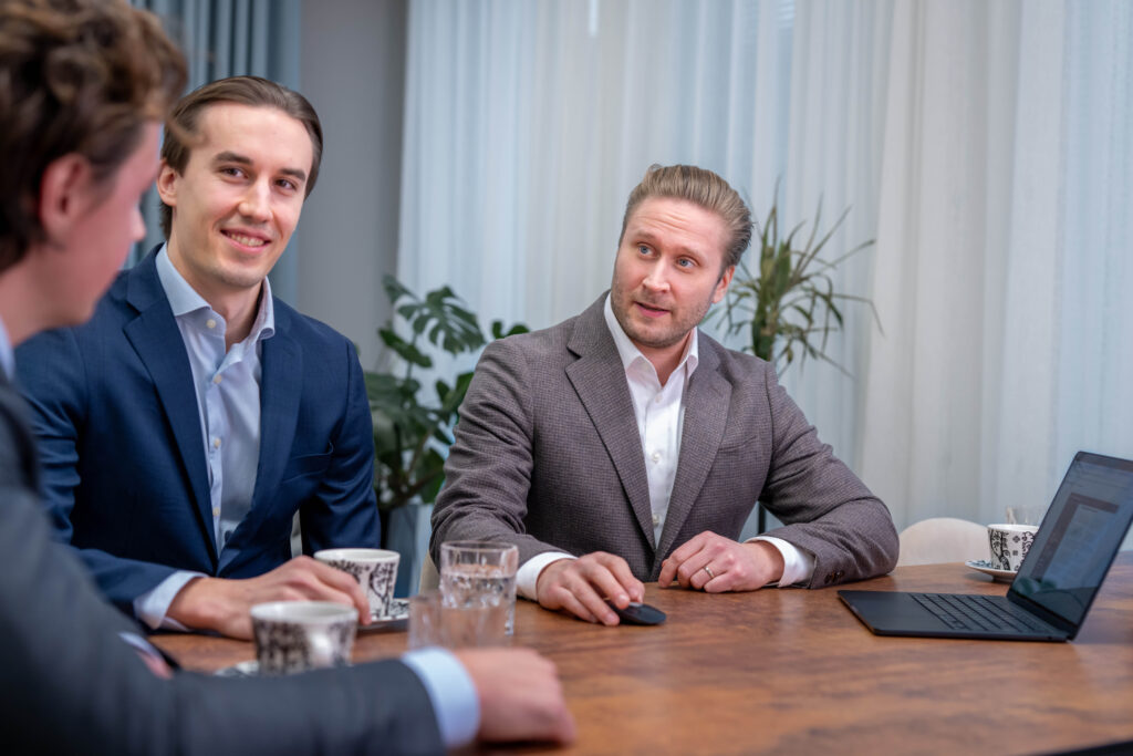 Springvestin asiamiehet keskustelevat iloisina neuvottelupöydässä