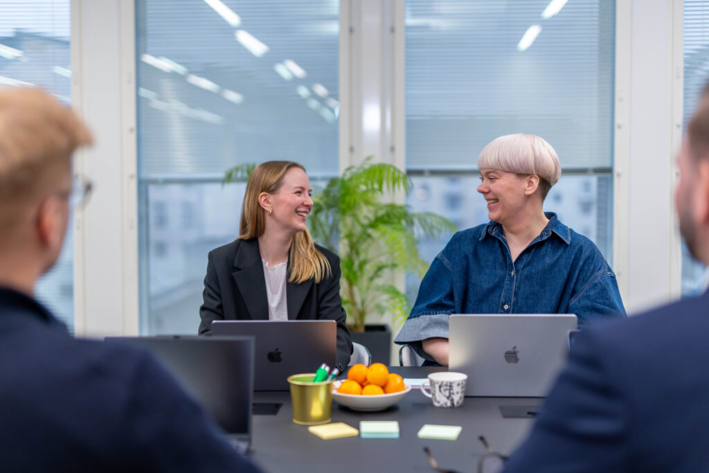 Springvestin asiantuntijat keskustelevat hymyillen toimistossa