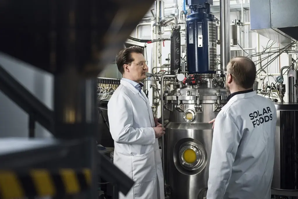 Solar Foodsin työntekijöitä tuotantolaitoksella soleiinia valmistavan laitteen edessä